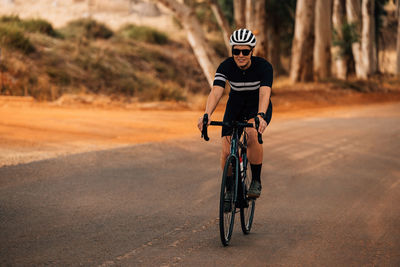 Young woman cycling on road