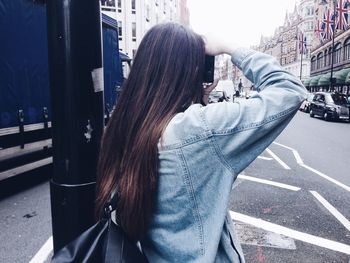 Woman photographing on street in city