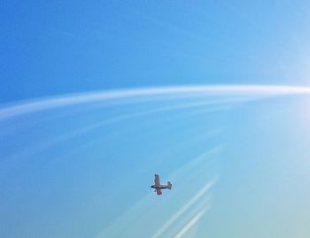 Low angle view of airplane flying against blue sky