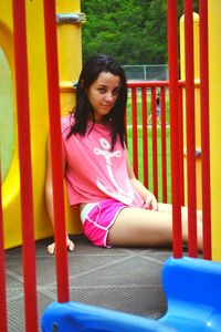Portrait of young woman sitting by slide