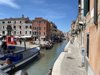 Boats in canal amidst buildings in city