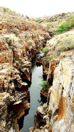 Scenic view of river amidst cliff against sky