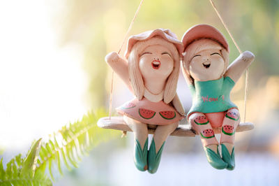 Close-up of figurine toy hanging on wood