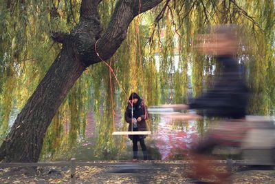 People sitting on tree trunk in forest