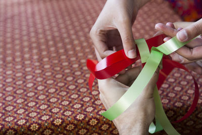 Midsection of woman holding red paper