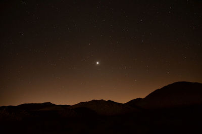 Scenic view of silhouette mountains against sky at night