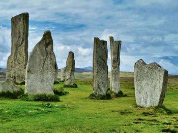 Rock formations on field against sky