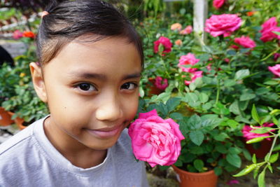 Close-up portrait of smiling girl with pink flowers