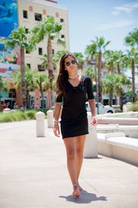 Portrait of woman standing against wall in city