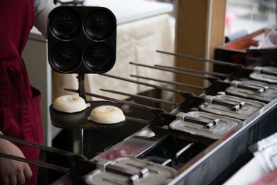 Cropped image of person preparing takoyaki