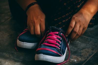 Low section of woman holding hands on floor