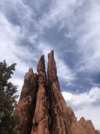 Low angle view of rock formation against cloudy sky