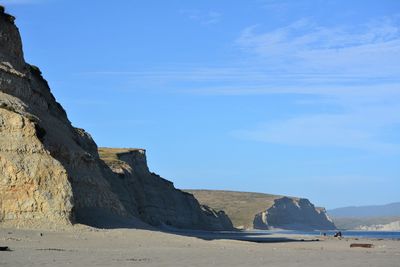 Rock formation on beach against sky