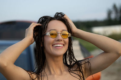 Young woman wearing sunglasses against sky