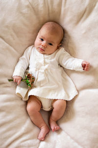 High angle view of baby lying on bed