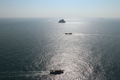 Boat sailing on sea against clear sky