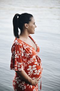 Young woman looking away while standing in water