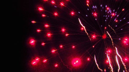 Low angle view of illuminated fireworks against sky at night