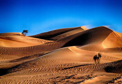 Scenic view of desert against clear blue sky