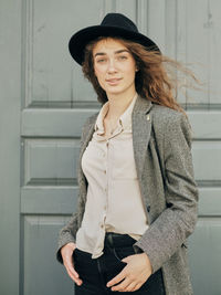 Portrait of woman standing against wall