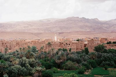 High angle view of cityscape and trees against mountains