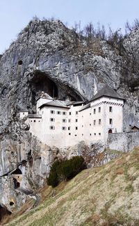 Old building by mountain against sky