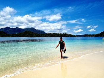 Full length of man on beach against sky