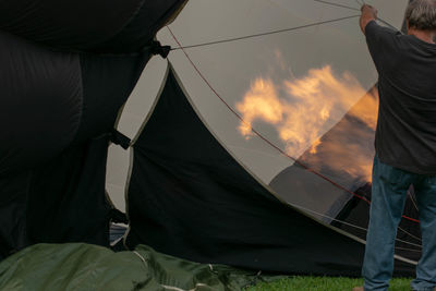 Rear view of person standing at tent against sky