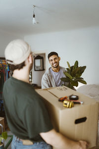 Happy man talking to boyfriend during relocation of house