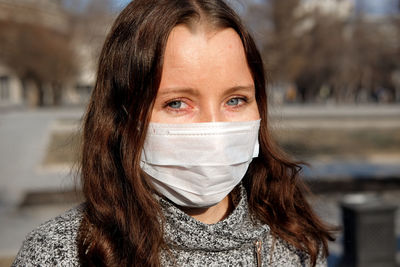 Close-up portrait of woman wearing scarf and knit hat outdoors during winter