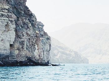 Scenic view of sea and mountains against clear sky