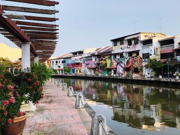 Canal amidst buildings in city against sky
