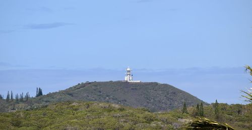 Lighthouse amidst buildings against sky