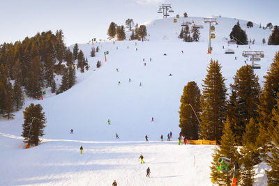 People skiing on snowcapped mountain against sky