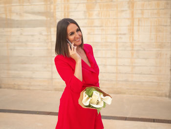 Young woman standing against wall