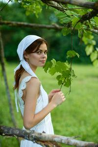 Portrait of smiling young woman holding plant