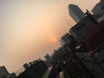 Low angle view of skyscraper against sky during sunset