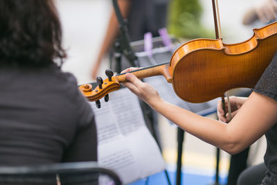 Midsection of man playing guitar at music concert