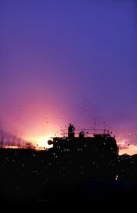 Silhouette trees against sky at night