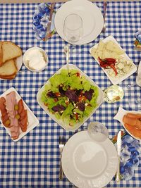 Greek salad on the table with appetizers and utensils.