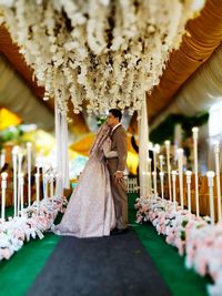 Rear view of woman standing by potted plants