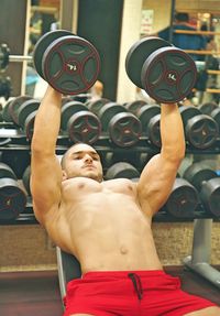 Shirtless man exercising at gym