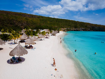 Panoramic view of people on beach against sky