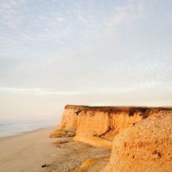 Scenic view of rocky beach against sky