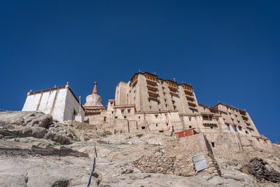 Low angle view of rock formations against clear blue sky