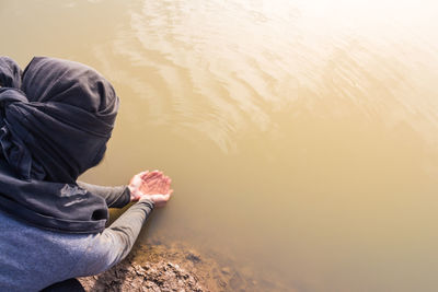 High angle view of woman holding water in lake