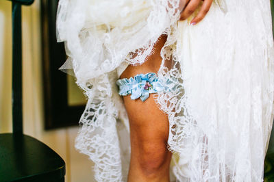 Midsection of bride wearing blue bow