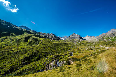 Scenic view of mountains against blue sky