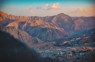 Aerial view of land and mountains against sky