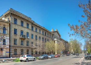 Street amidst buildings against clear blue sky